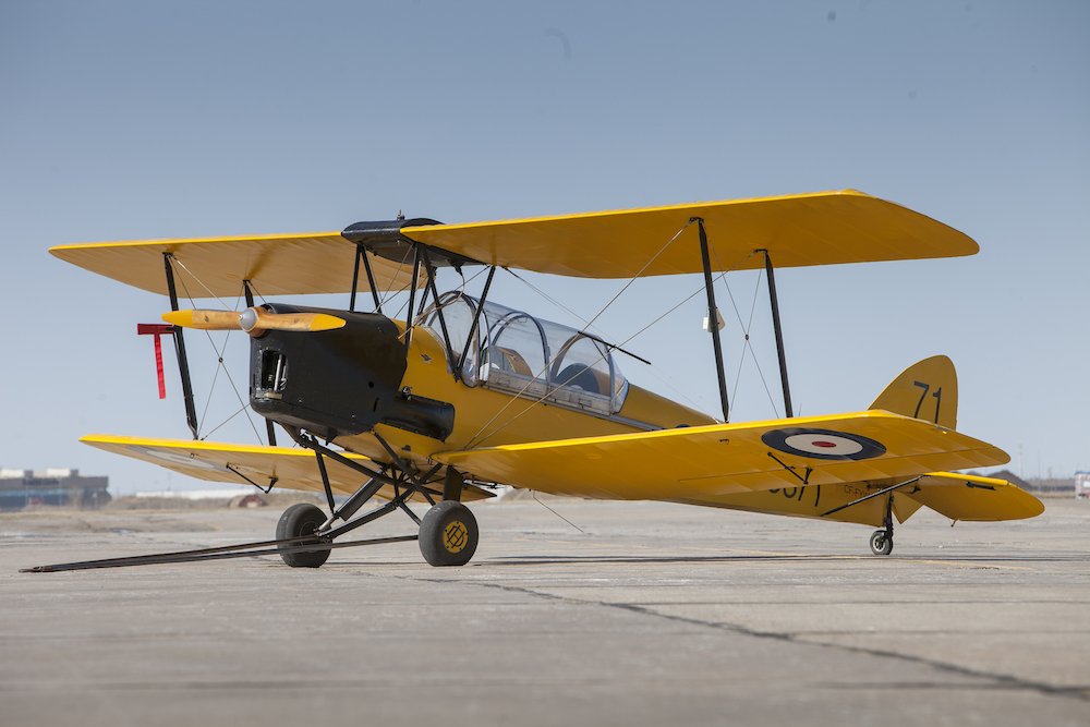 Yellow 1942 de Havilland Tiger Moth biplane on the apron